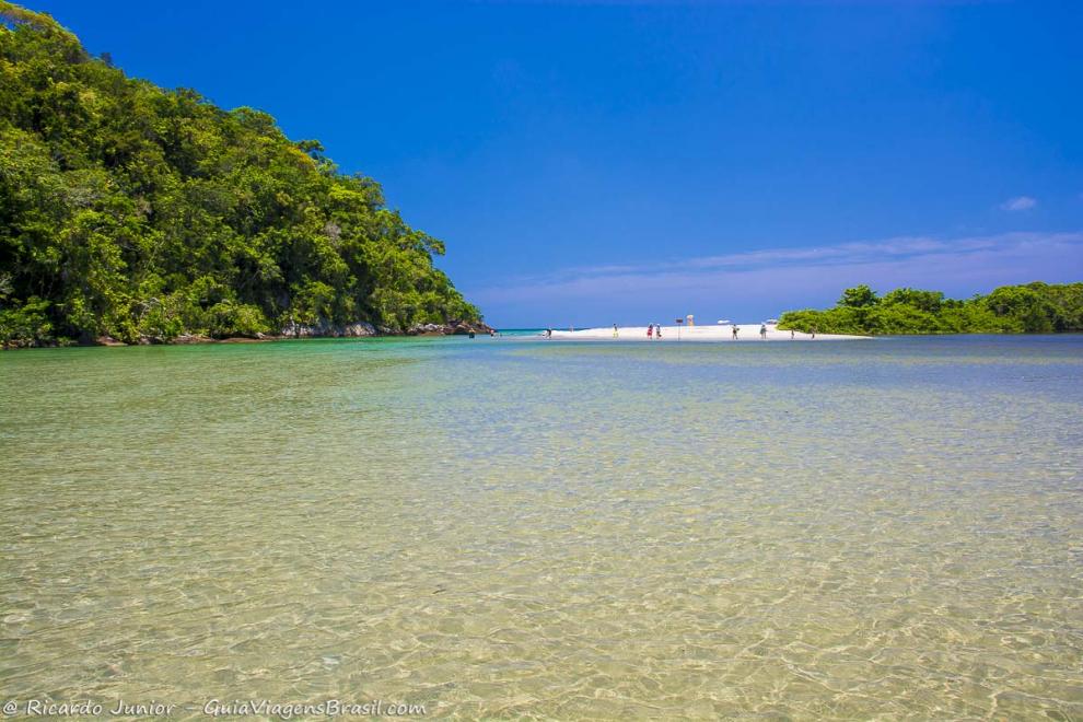 Imagem da piscina natural e ao fundo areia da praia.